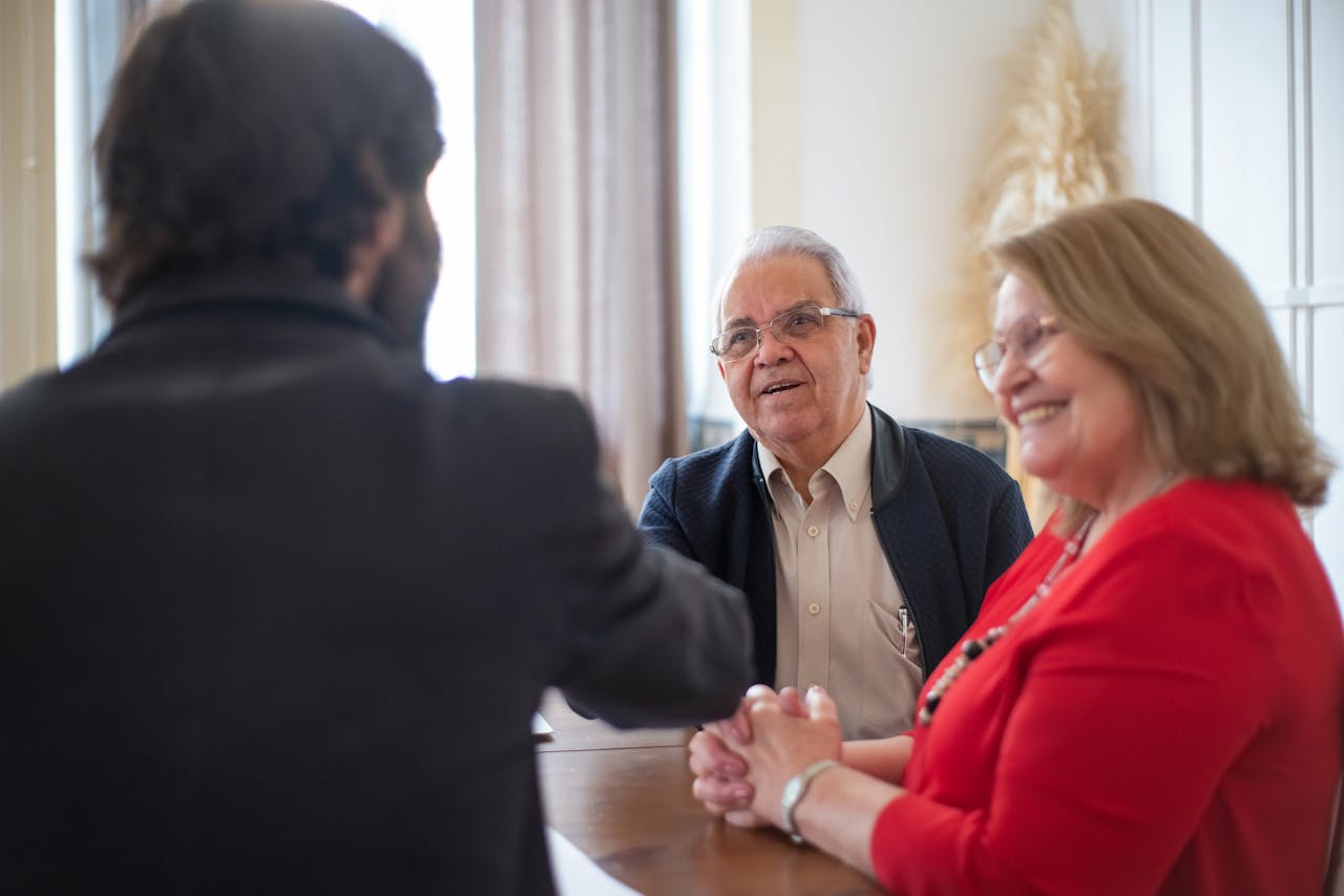 Senior couple meeting with a professional at a bright interior space, showcasing a positive and engaging discussion.